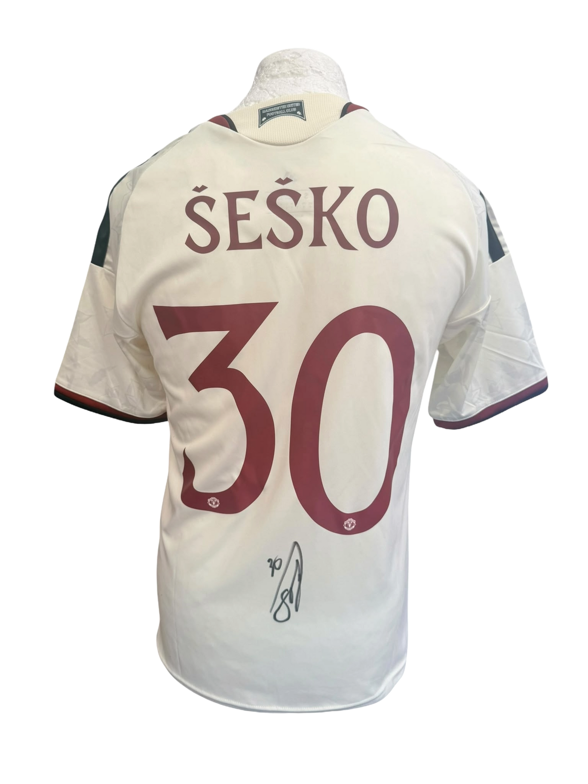 Back view of an ivory 2026/27 Manchester United third shirt with custom club font printing hand-signed in permanent marker by Benjamin Sesko.