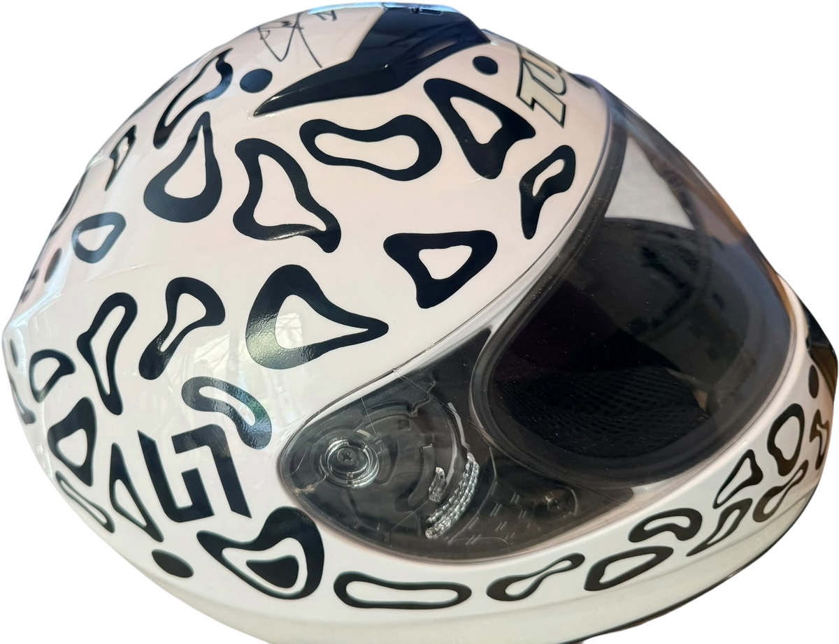 Profile view from the left side of the full-size replica Lando Norris racing helmet, showing intricate sponsor decals and aerodynamic shell design.