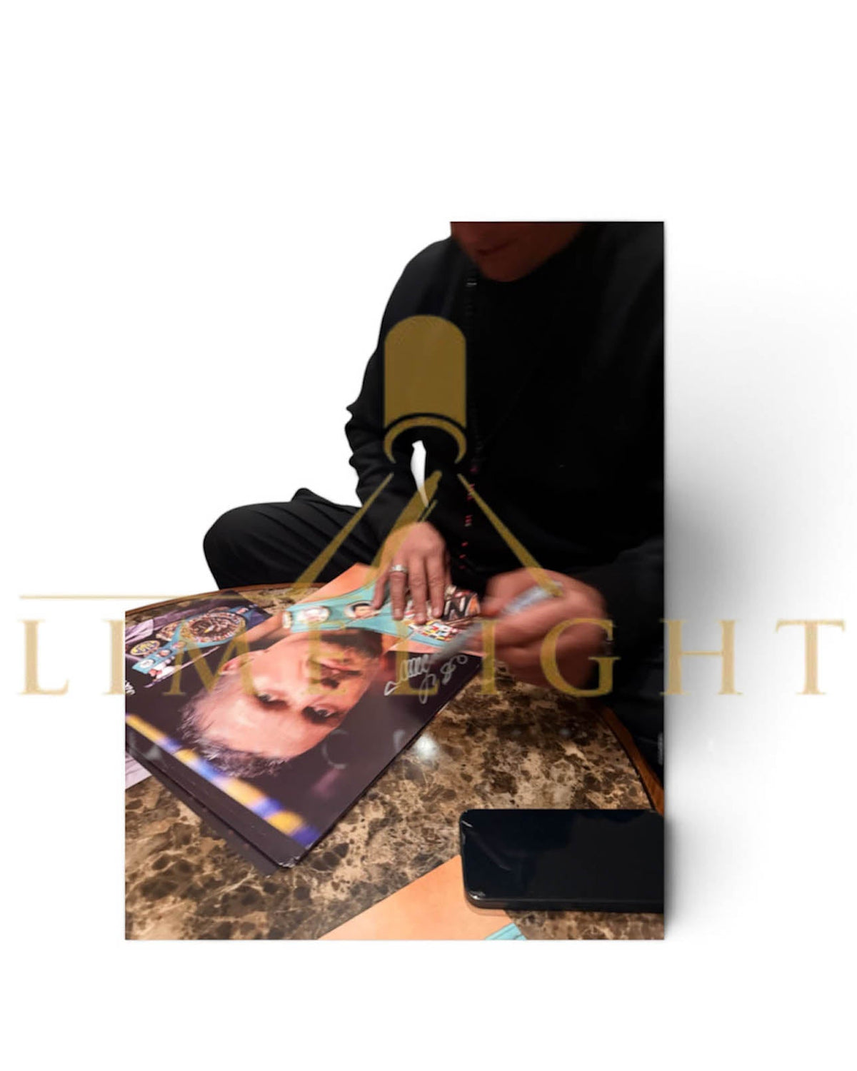 Photo proof of Oleksandr Usyk hand-signing memorabilia with a bold black marker during an exclusive private signing session