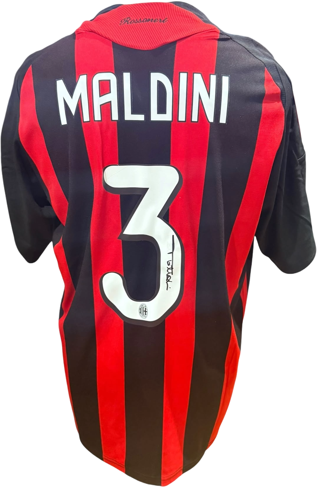 Rear view of a replica retro AC Milan home shirt hand-signed on the back by defender Paolo Maldini, displayed alongside the Certificate of Authenticity.