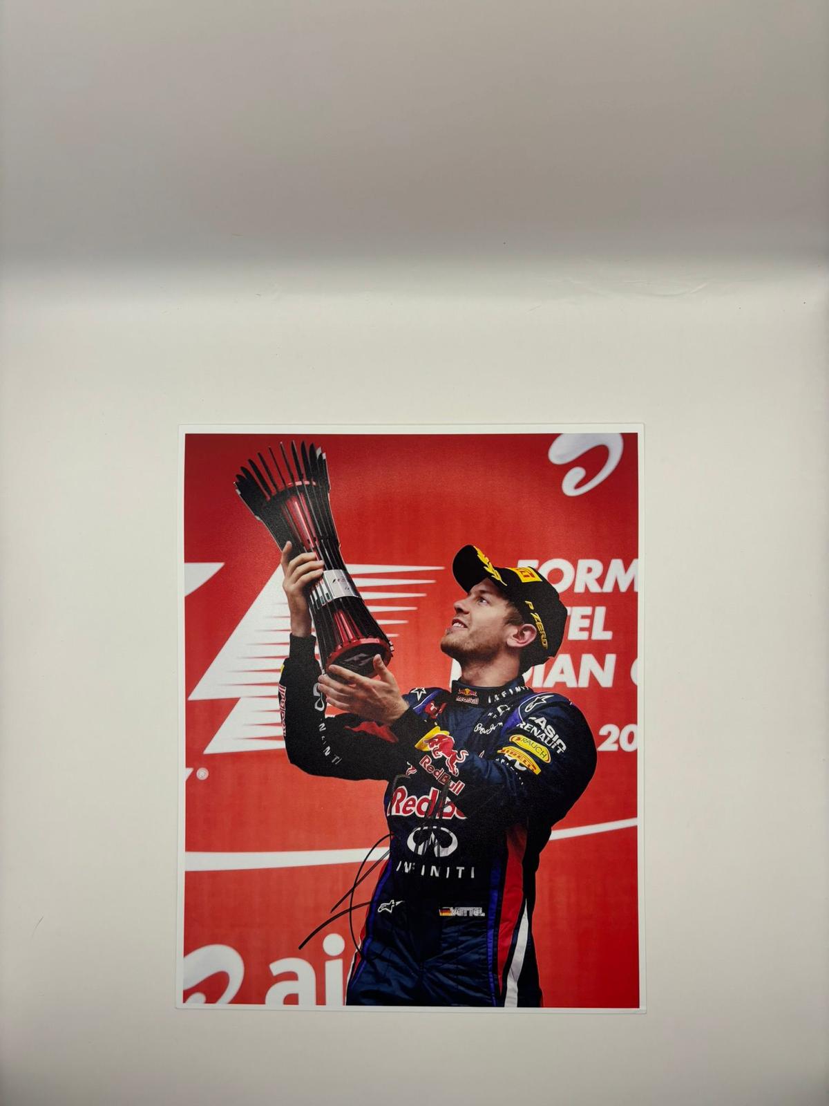 Authentic 8x10 action photograph of Sebastian Vettel in his Red Bull Racing kit, hand-signed by the four-time World Champion in bold black ink with a Limelight Memorabilia COA.