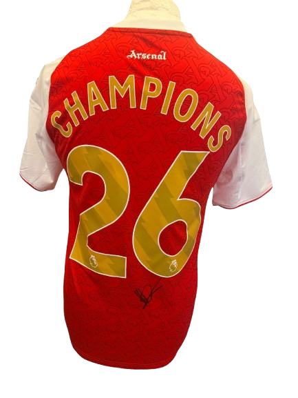 Hand-signed Mikel Arteta Arsenal 2025/2026 home shirt with authentic autograph and commemorative gold Champions 26 printing on the back.
