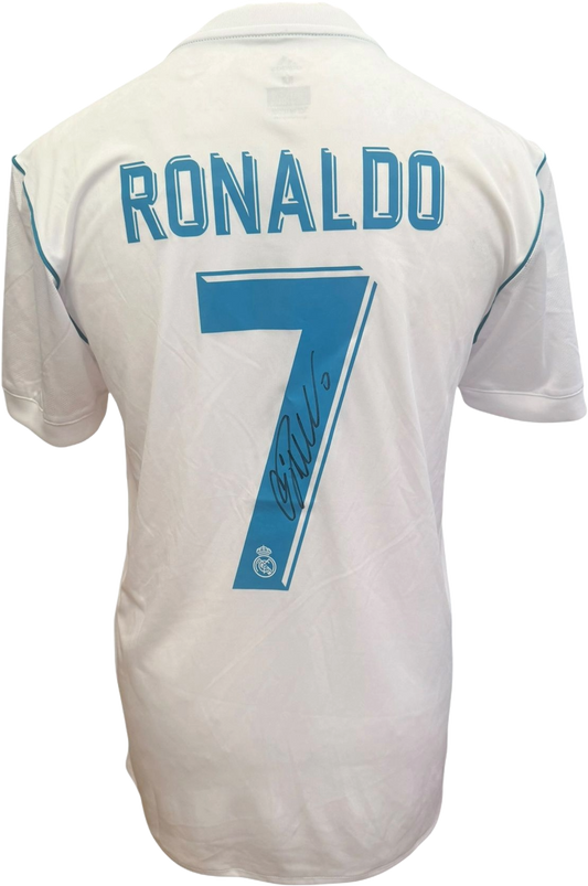 Framed signed football shirts featuring modern and retro designs on display.