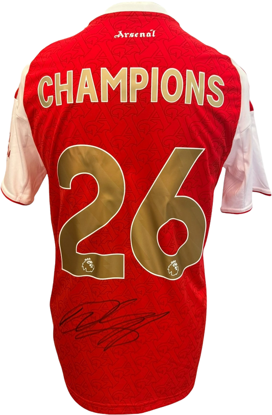 Close-up view of the Declan Rice Signed Arsenal Premier League Champions 2026 Shirt, showcasing the commemorative gold trophy graphic, unique championship lettering, and a crisp hand-signed autograph on the reverse of the kit.