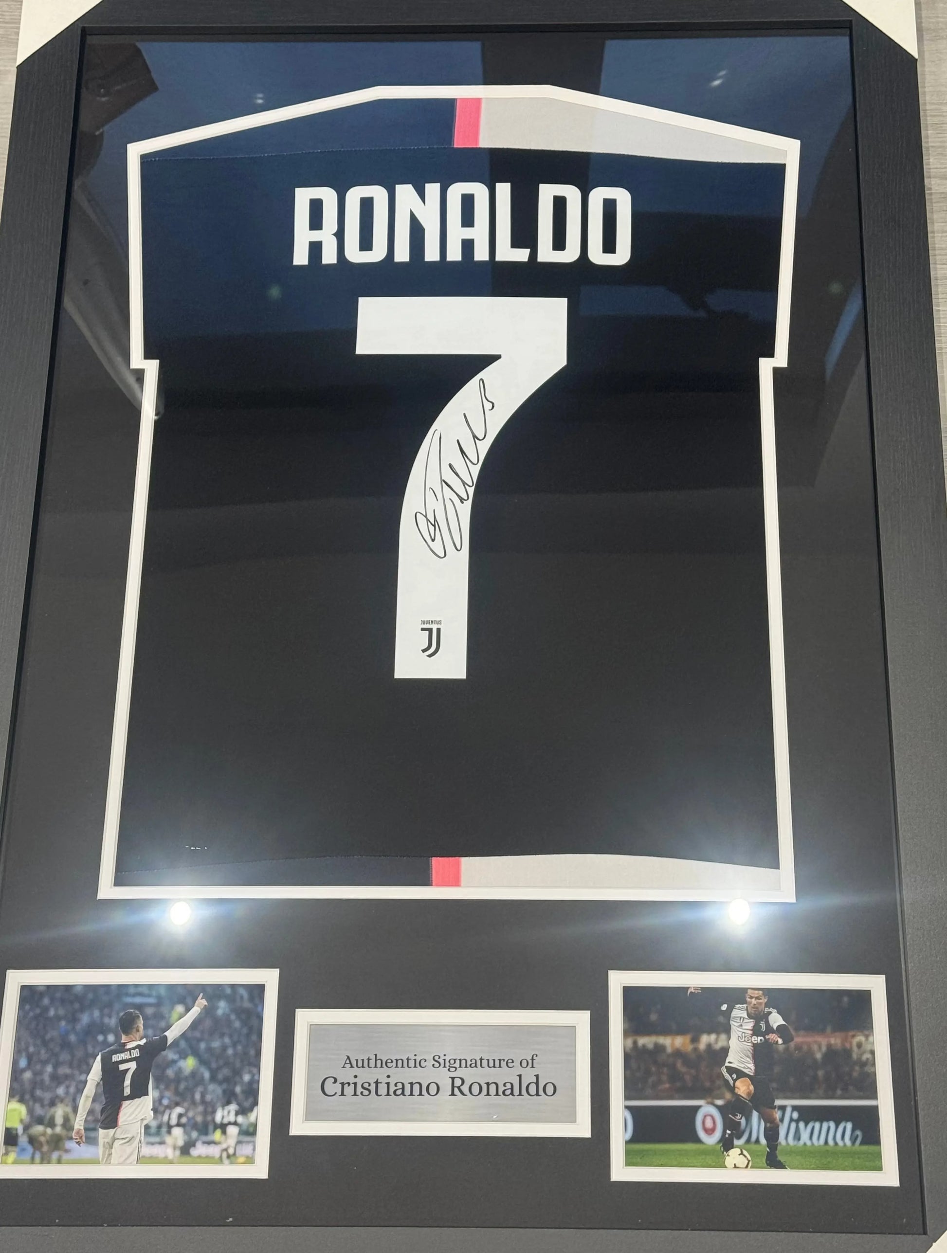Deluxe framed 2019/20 Juventus Home Shirt, hand-signed by Cristiano Ronaldo. The frame includes plaques, montage photos, and a clear view of the signature.