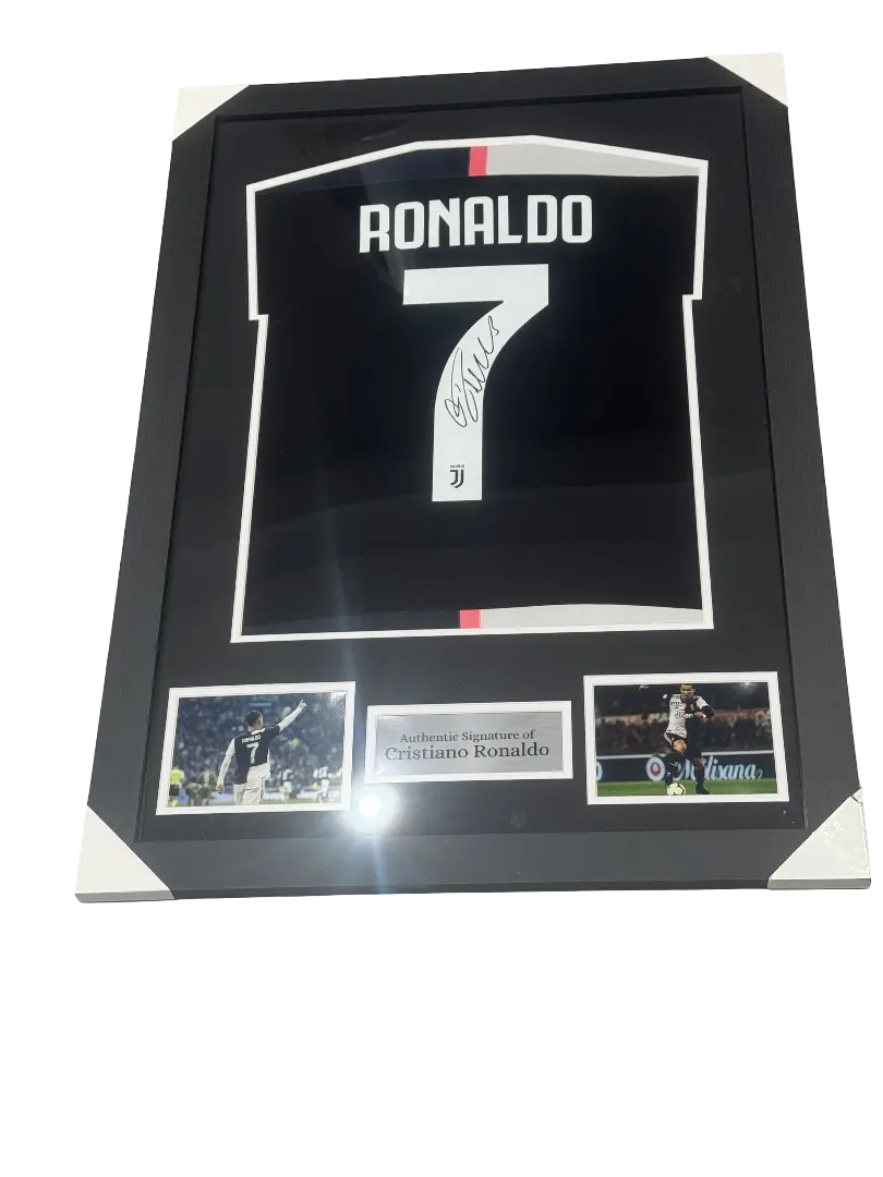 Deluxe framed 2019/20 Juventus Home Shirt, hand-signed by Cristiano Ronaldo. The frame includes plaques, montage photos, and a clear view of the signature.