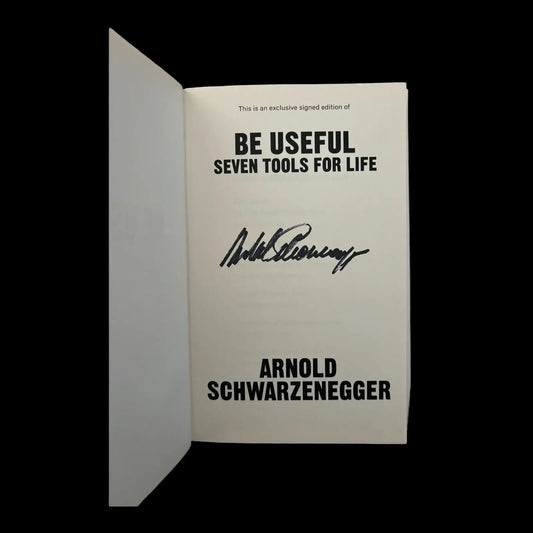 Signed book by Arnold Schwarzenegger, showing his clear, bold signature on the opening page. Book cover and signature are visible.