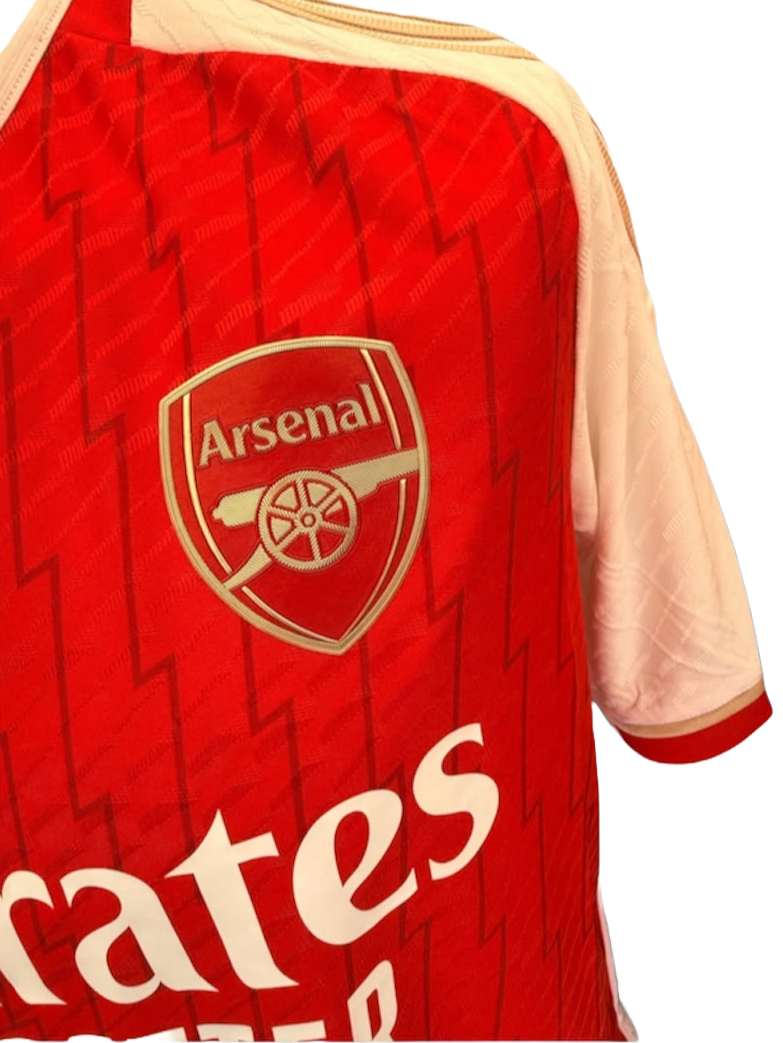 Close up detail of the heat-applied Arsenal club badge and lightning bolt fabric pattern on the 2023/24 home shirt