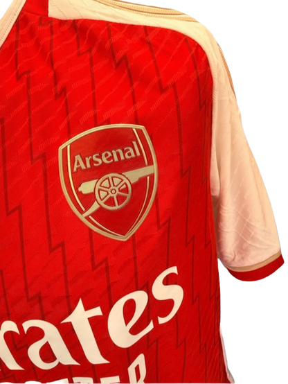 Close up detail of the heat-applied Arsenal club badge and lightning bolt fabric pattern on the 2023/24 home shirt