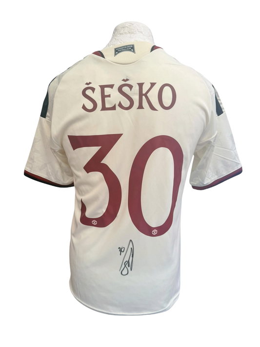 Back view of an ivory 2026/27 Manchester United third shirt with custom club font printing hand-signed in permanent marker by Benjamin Sesko.