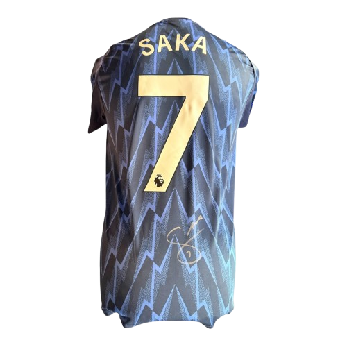 Close-up detail of Bukayo Saka's authentic signature on the 2025/26 blue Arsenal away jersey.