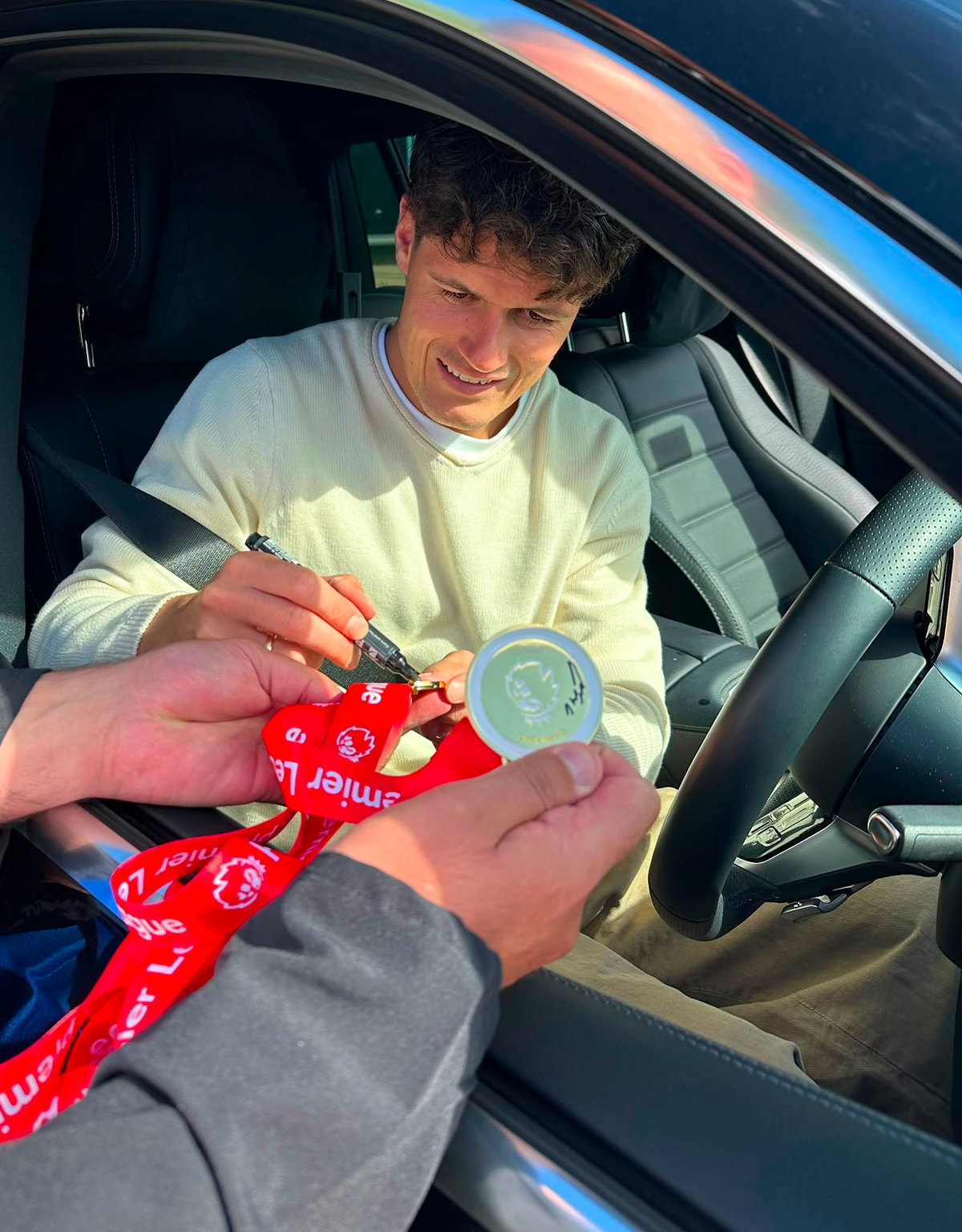 Photo proof showing Christian Norgaard hand-signing the Arsenal Premier League Champions medals.
