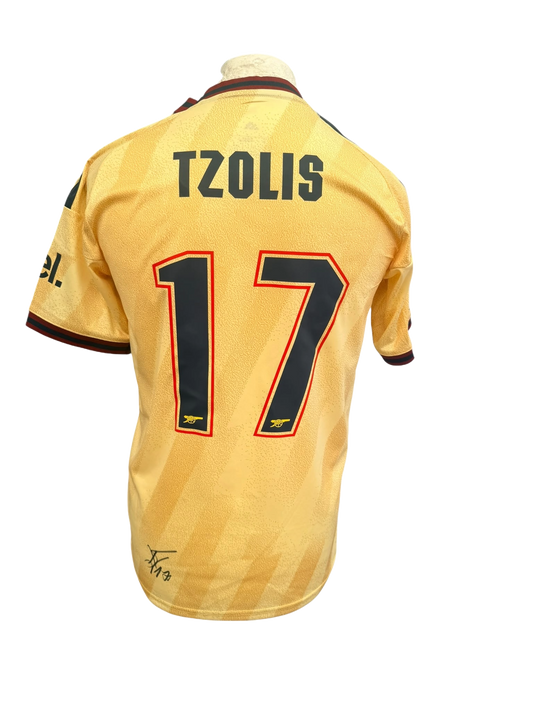 Back view of a pale yellow 2026/27 Arsenal third shirt hand-signed in permanent marker directly on the back by Christos Tzolis.