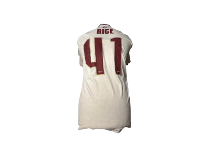 Detailed close-up of Declan Rice's hand-signed autograph on the Arsenal 2025/26 white third shirt, showing the official club font and Art Deco fabric texture.