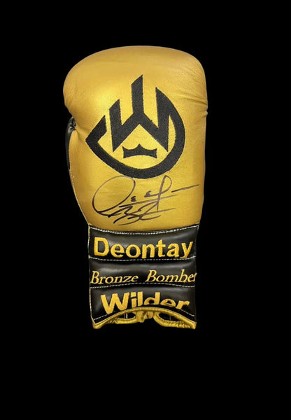Authentic gold boxing glove hand-signed by Deontay Wilder in black permanent marker, featuring the signature of the former WBC Heavyweight Champion.