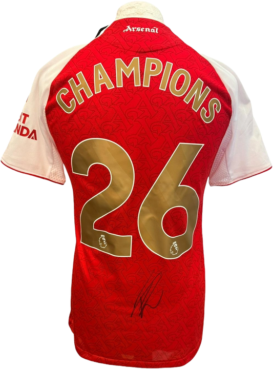 The reverse of the authentic player version 2025/26 Arsenal home shirt showcasing the commemorative gold 'Champions 26' printing and Eberechi Eze's hand-signed autograph on the fabric.