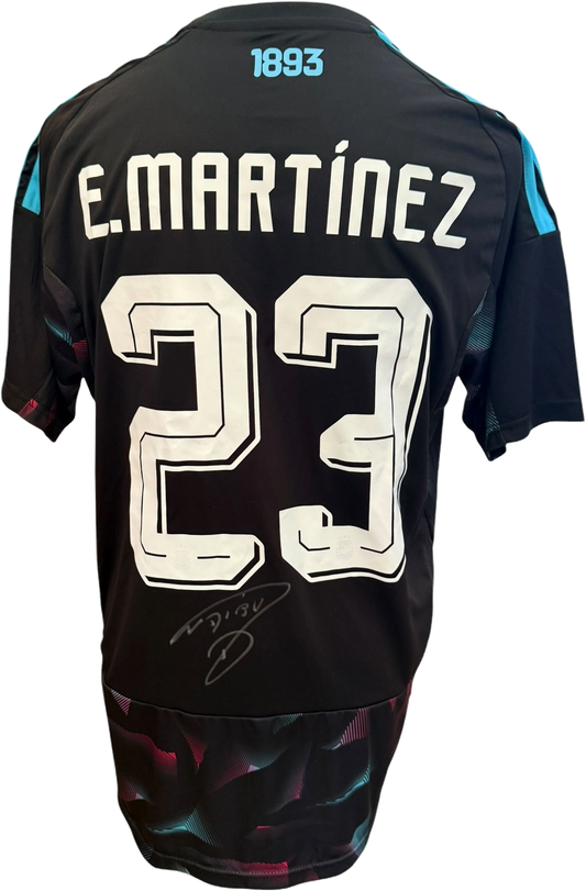 The reverse of the white and sky-blue Argentina jersey showing Emiliano Martinez's squad number alongside his bold, hand-signed autograph in silver marker.
