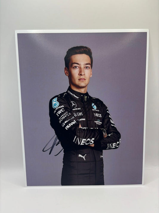 A high-gloss professional racing photograph hand-signed by George Russell in silver permanent marker, featuring the Mercedes-AMG F1 car and a COA.