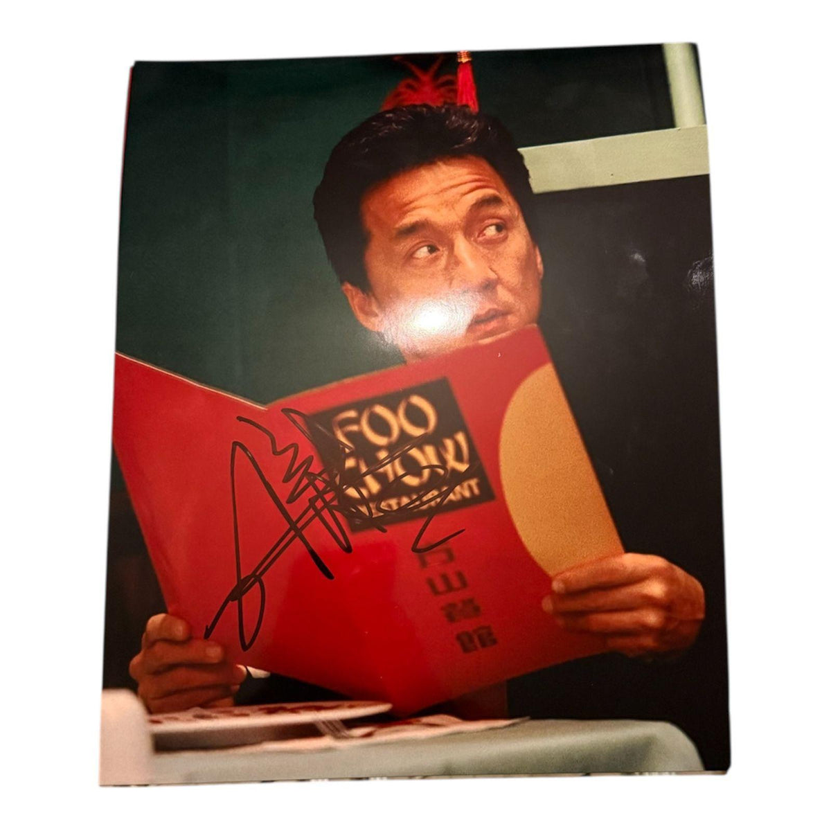 Authentic hand-signed action photograph of Jackie Chan as Chief Inspector Lee in Rush Hour, signed in bold permanent marker with an official Limelight Memorabilia COA.