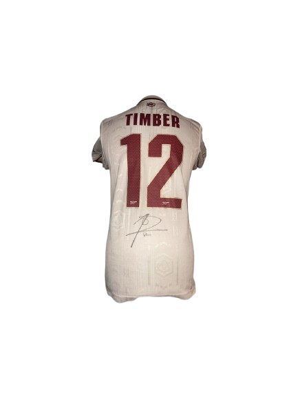 Authentic Jurrien Timber signed Arsenal third shirt 25/26 featuring a large, bold black signature on the white and maroon Highbury anniversary jersey.