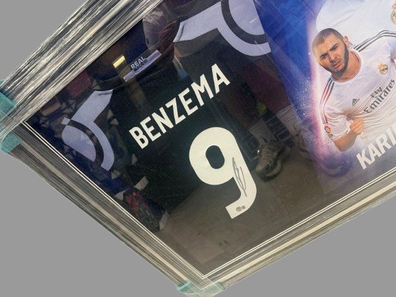 Close-up of Karim Benzema's authentic hand-signed autograph in black marker on a Real Madrid jersey.