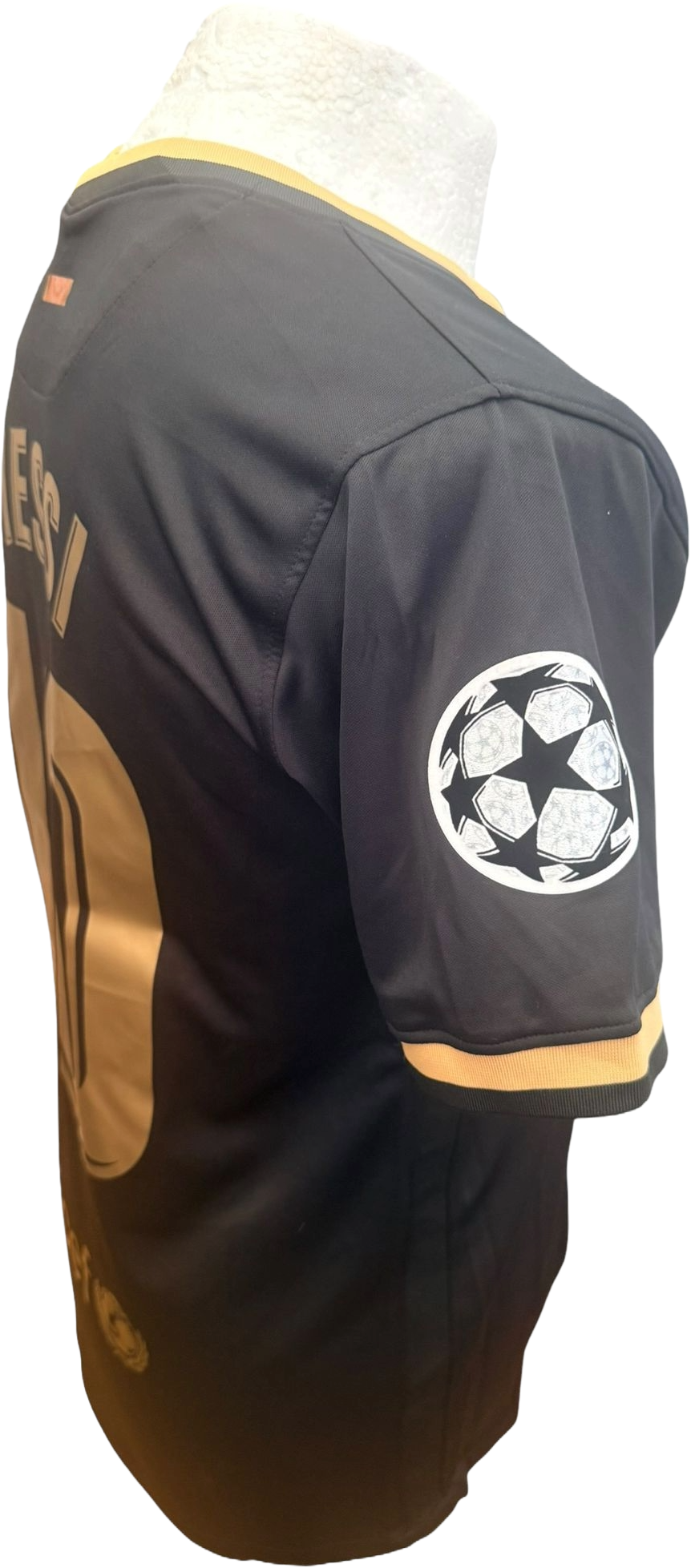 Close-up side view of the Barcelona black away shirt highlighting the Champions League starball sleeve badge detail.