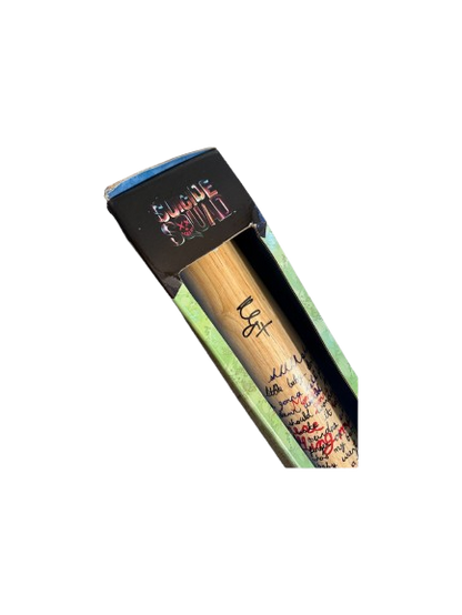 A high-resolution closeup of Margot Robbie's bold black ink signature on the wooden grain of the Harley Quinn "Good Night" replica prop bat.