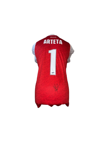 Authentic Mikel Arteta signed Arsenal home shirt 25/26 featuring a bold black signature on the classic red and white jersey with tonal Gothic A patterns.