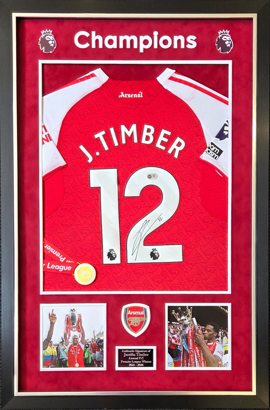 Premium framed display featuring a hand-signed Jurrien Timber Arsenal home shirt with 2025/26 Champions details and a replica league medal.