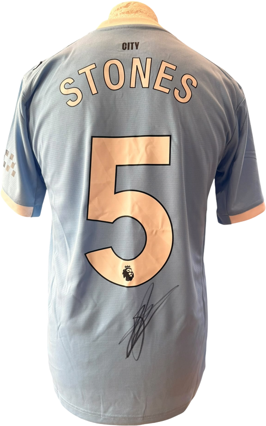 Unframed hand-signed John Stones Manchester City 2025/26 home shirt showcasing the clean autograph on the back.
