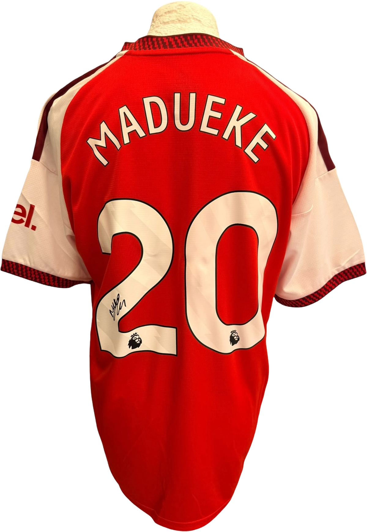 Close up shot of an authentic hand-signed autograph by winger Noni Madueke across the front of the red and white Arsenal 2026/27 home shirt.