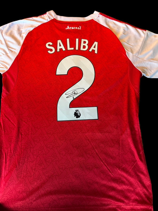 Official 2025/26 Arsenal home shirt hand-signed by William Saliba in bold permanent ink.